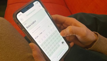 Hand håller i mobiltelefon