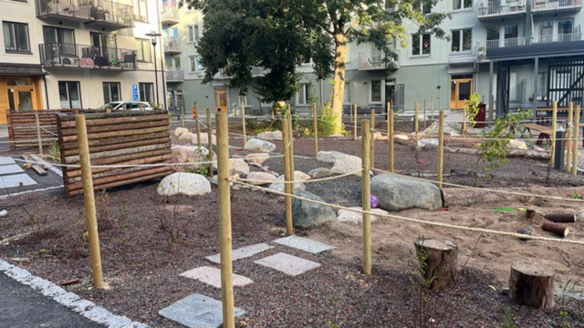 Innergård mellan två hus, med grusgångar och ett stort träd