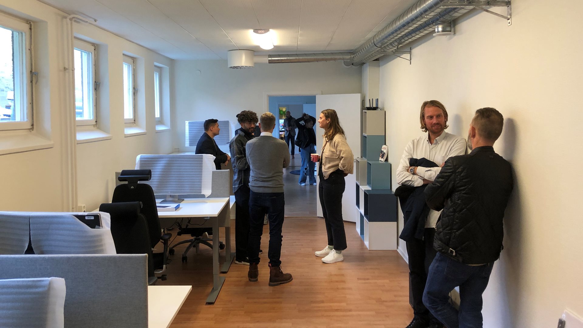 Kontorslokal med grupper av samtalande människor