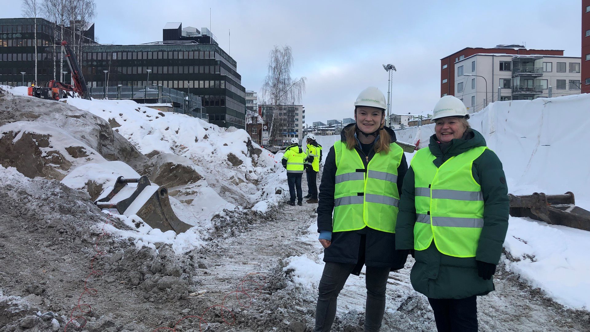 Två kvinnor i hjälp och varselväst på byggarbetsplats