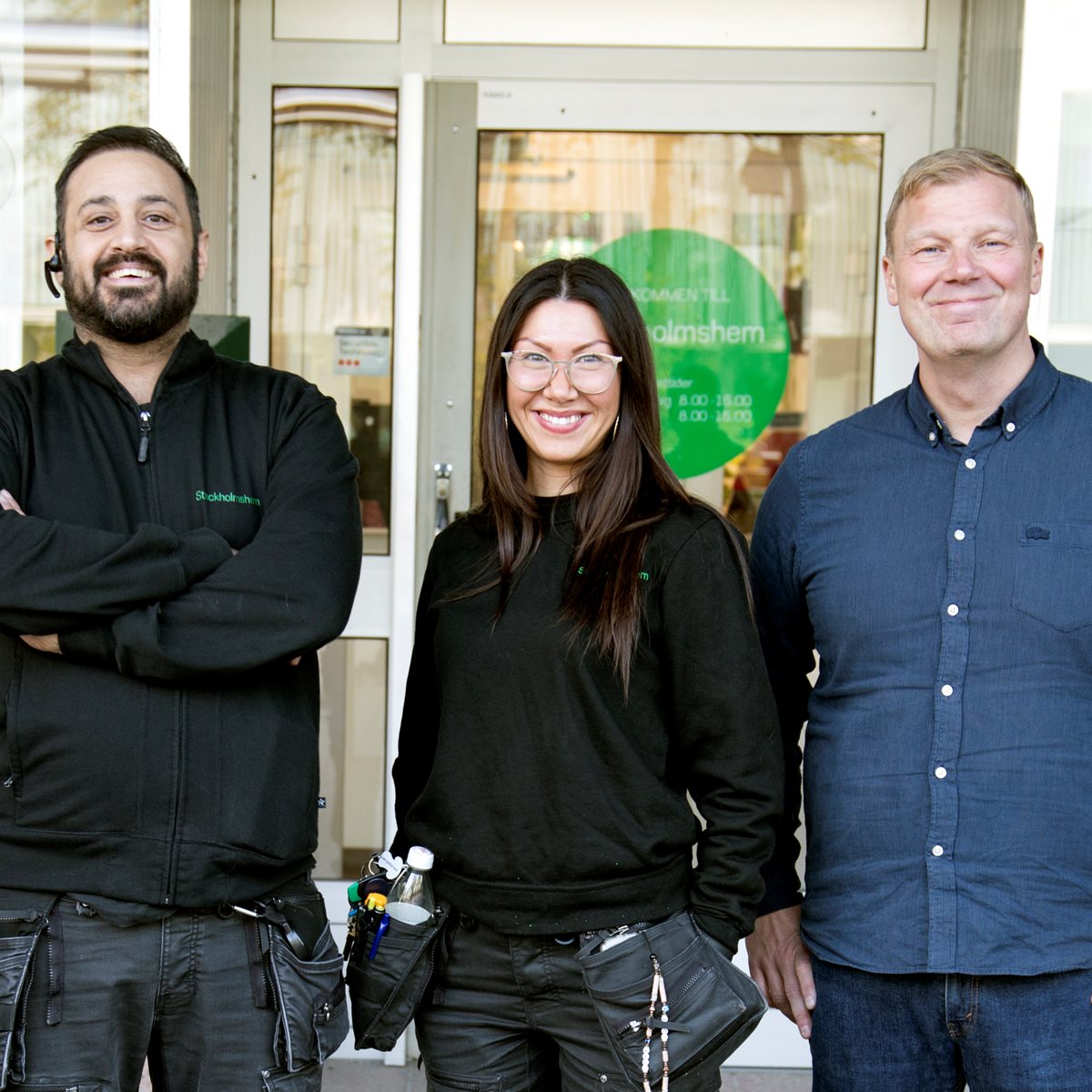 Tre kollegor utanför ett Stockholmshemskontor