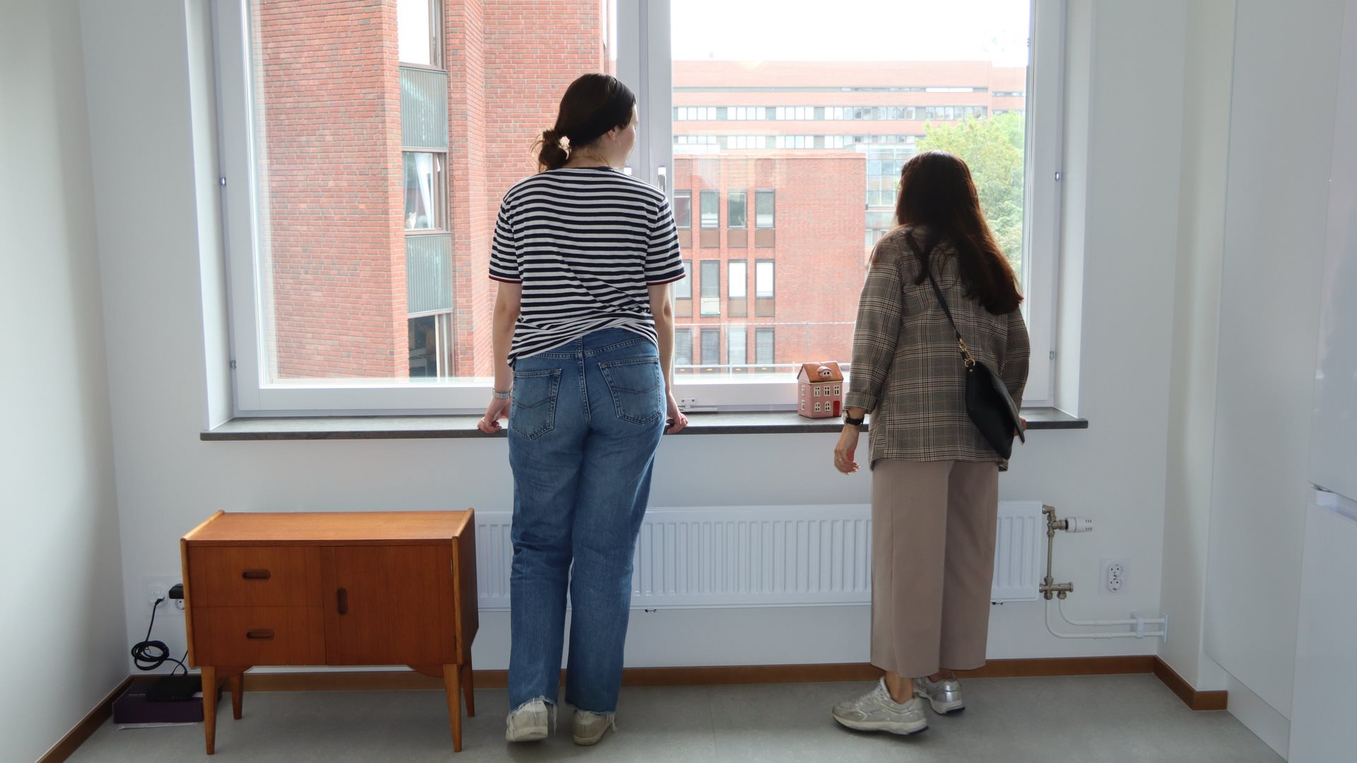 Två kvinnor tittar ut genom fönster