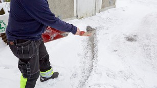 man som sandar snöig trottoar