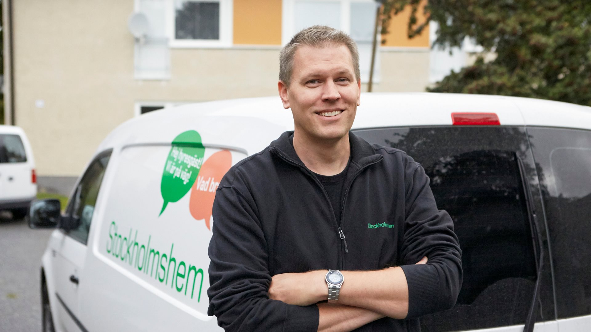 Leende man framför bil