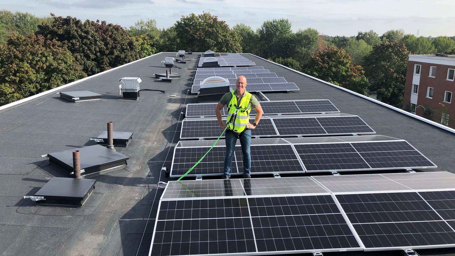 Solceller och en man på ett platt tak