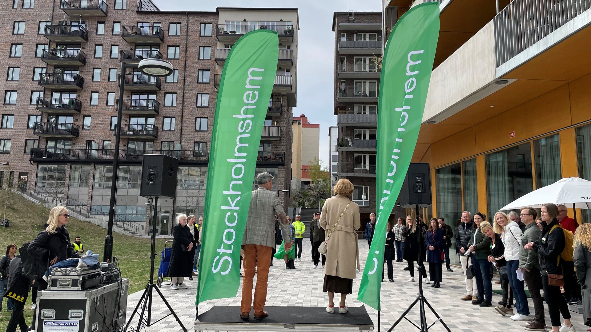 Event, invigning, beachflaggor med Stockholmshem framför husfasad