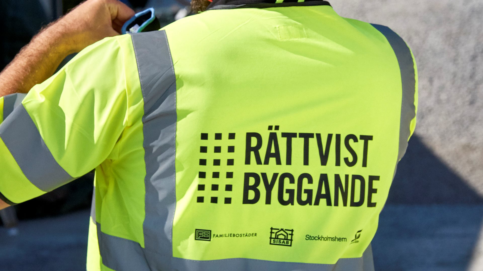Man med varselväst med texten Rättvist byggande