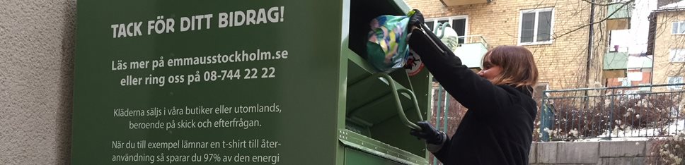 Kvinna slänger en påse kläder i textilinsamlingscontainern som står på Brännkyrkagatan 127. 