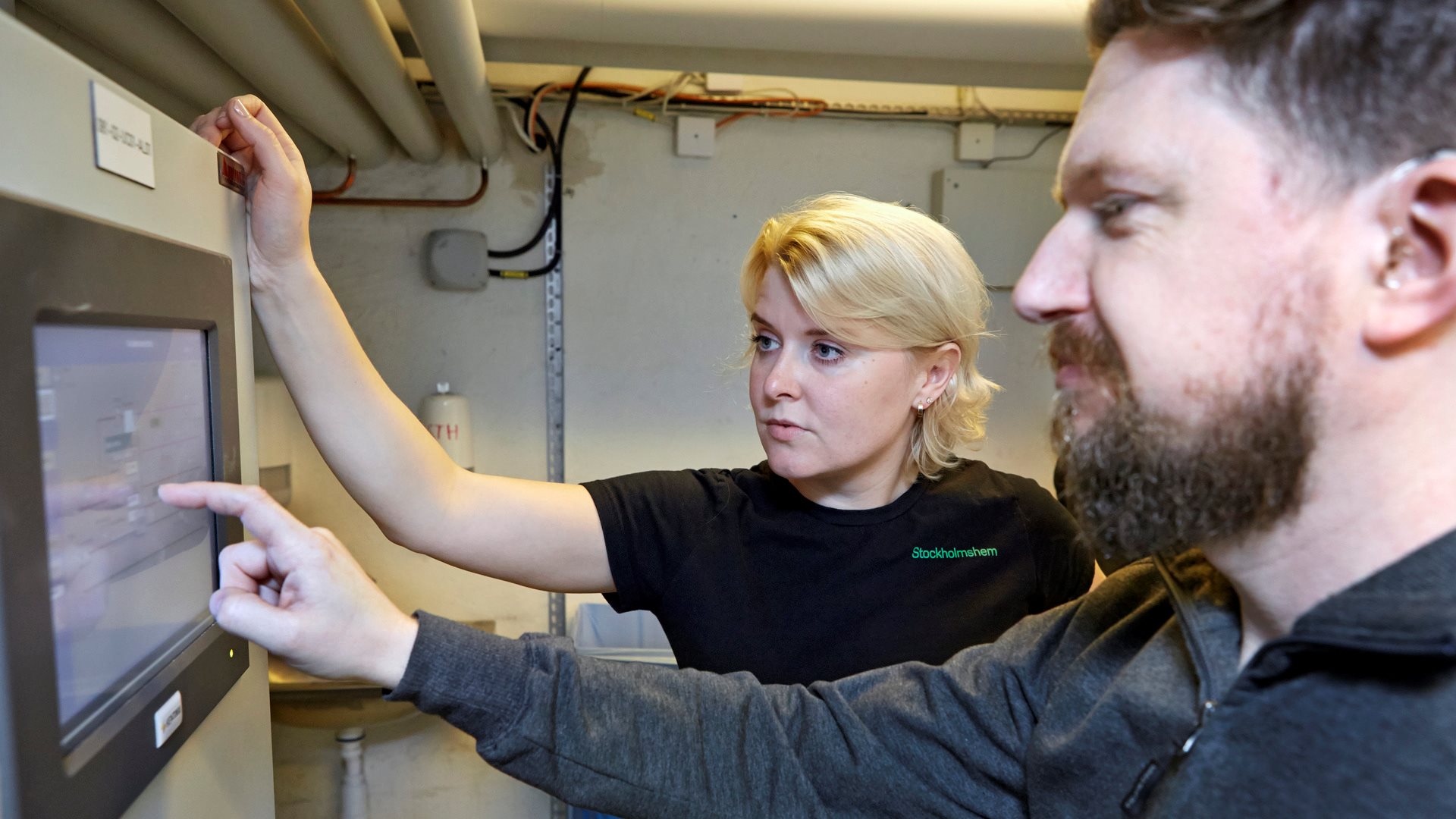 Man och kvinna kontrollerar elcentral