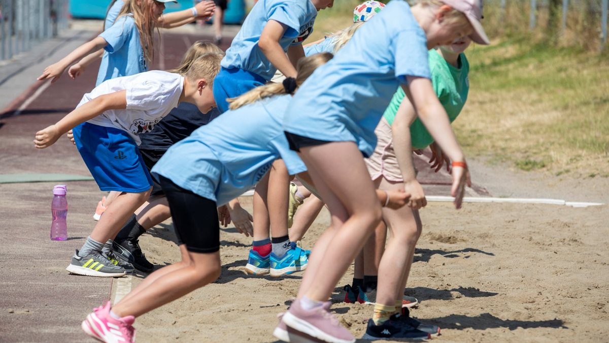 En grupp barn som hoppar längdhopp