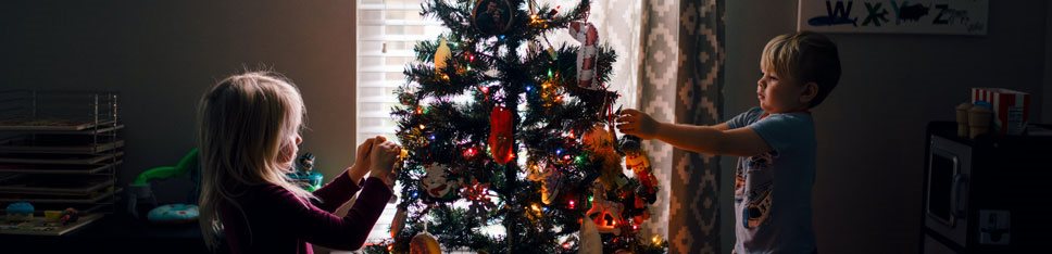 Två barn klär en julgran