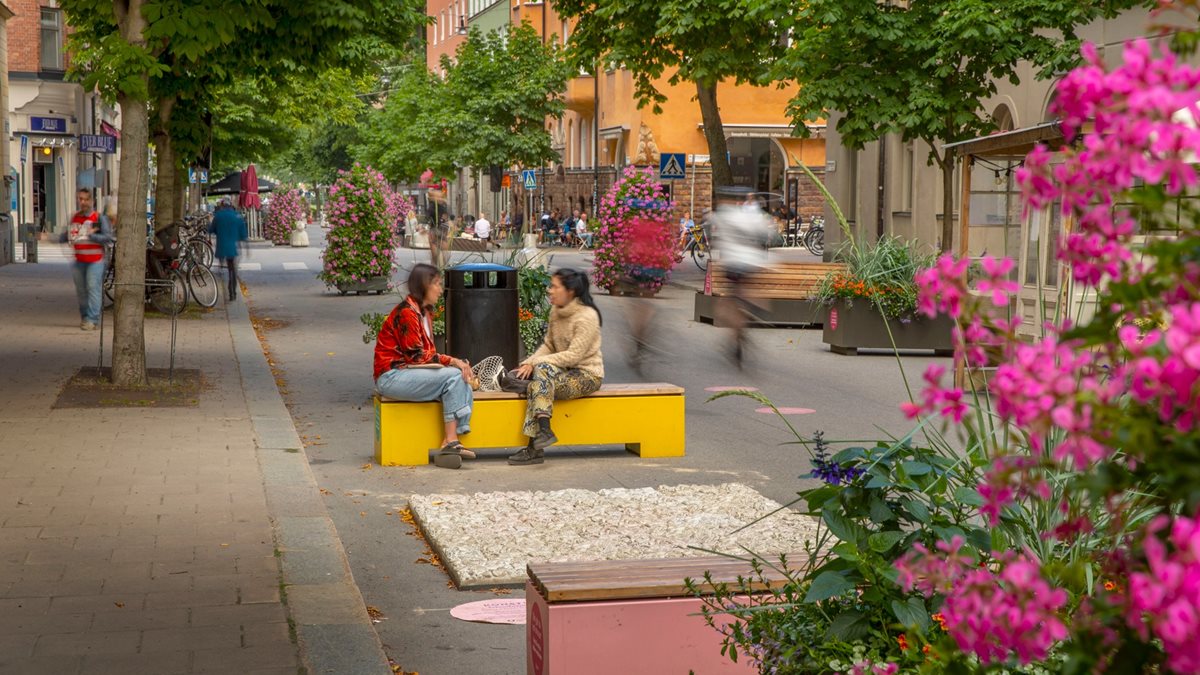 Blomsterplanteringar och bänkar på gata i Stockholm