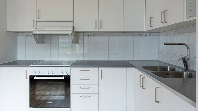 Kök med vitt kakel och vita köksluckor