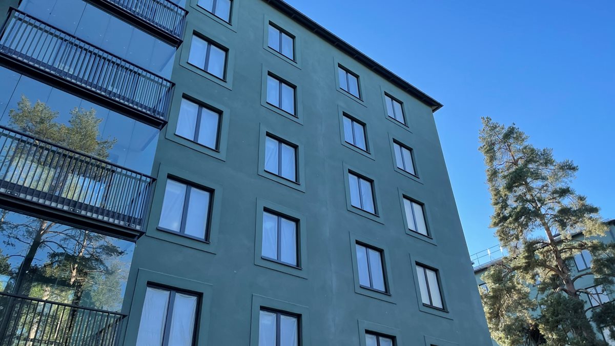 Hus med grön fasad och inglasade balkonger